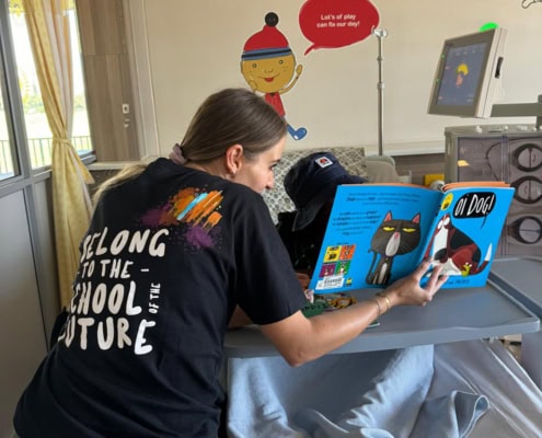 A Think Digital Academy staff member reading a book to a child in hospital on World Book Day.
