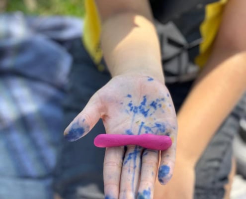 Playing with clay during sensory play in a park with Think Digital Academy virtual school.