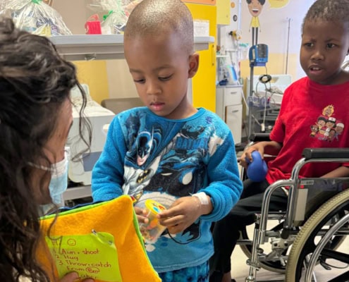 Little boy receiving gifts while in hospital to celebrate Nelson Mandela Day in 2024.