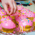 Cupcakes with pink icing and all the toppings.